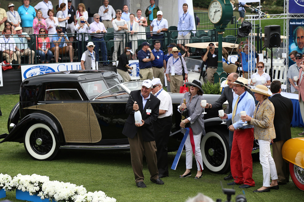 Amelia Island Concours d’Elegance founder Bill Warner opening a champagne bottle